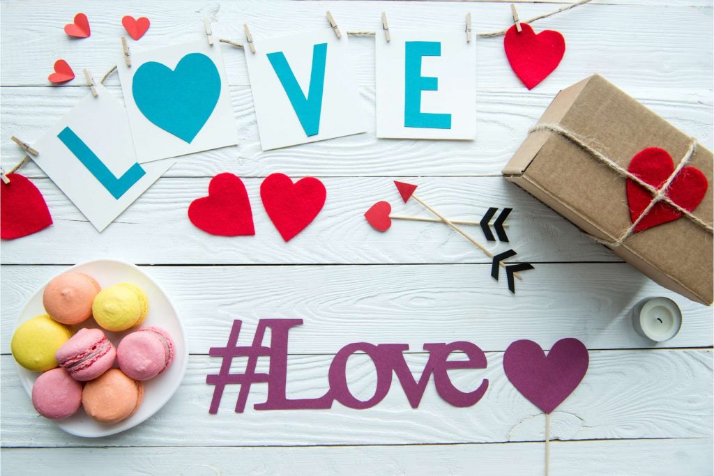dekoracije u obliku srca, pokloni, kolači i hashtag za Love